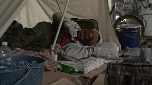 Middle-Aged Vagrant Trying to Get Asleep Lying on Mattress in Tent Feeling Sick
