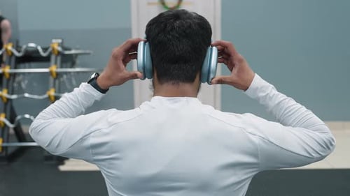 Rear View Athlete Adjusting Headphones Before Bench Press Lift