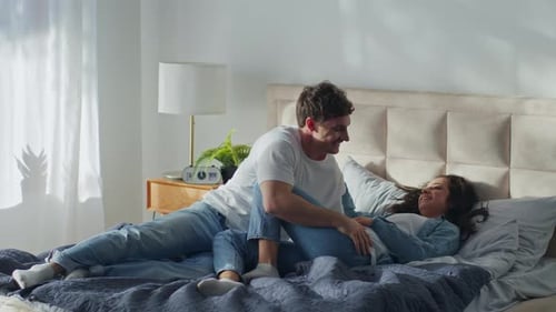 Caucasian Man Woman Lying Together on Bed Boyfriend Girlfriend at Home Bedroom Laughing Smiling