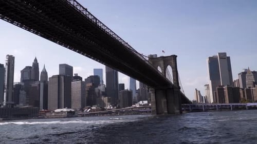 Iconic New York City Brooklyn Bridge with Manhattan in the background during sunny weather. Slow mot