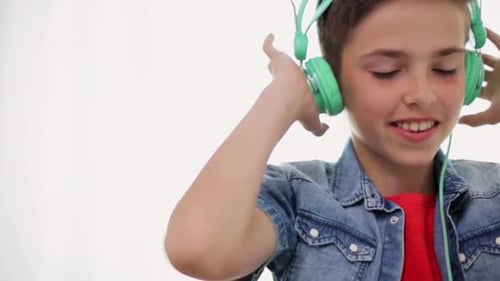 Boy smiles wearing headphones while listening to music