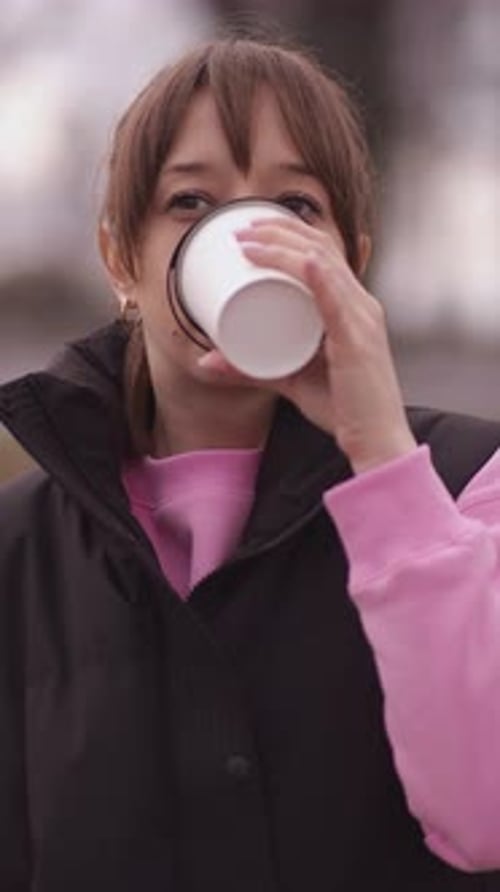 Young woman enjoying a hot beverage outdoors