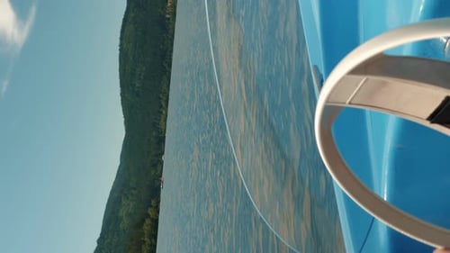 Electric boat sailing on lake, close up of hands turning wheel. Vertical video