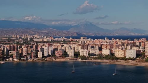 Panoramic View of Alicante City with Residential Buildings Coastline and Distant Mountains Under a