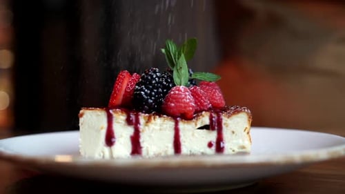 Tarta de queso con cobertura de frutos rojos, azúcar y azúcar (cámara lenta)