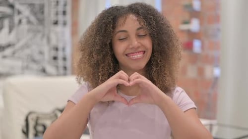 Smiling Woman Makes Heart Shape With Her Hands