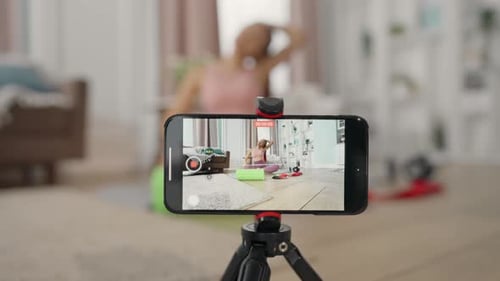 Tutorial de grabación de yoga para mujer con teléfono inteligente en un estudio doméstico, transmisión de acondicionamiento físico femenino
