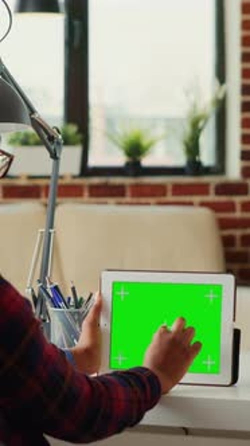 Person Using Tablet with Green Screen Indoors