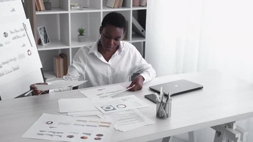 Woman Analyzing Data at Bright Desk in Office