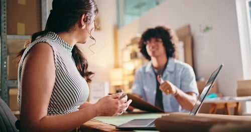Enthusiastic Coworkers Discussing Project on Laptop