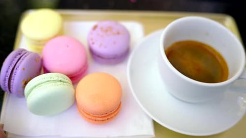 Colored french macarons with a cup of black cofee