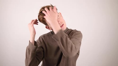 Young Adult Adjusts Hair Looking Concerned