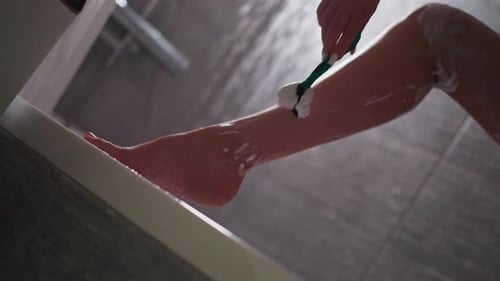 Woman Shaving Leg in Shower