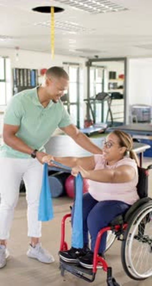 Therapist Assists Woman in Wheelchair with Exercises