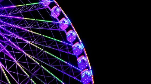 Lit up Ferris Wheel in Motion at Night