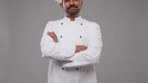 Happy indian chef in toque invites you to enjoy gourmet cooking