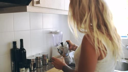 Woman Pours Coffee In Sunny Kitchen