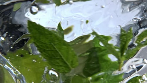 Primer plano del cóctel de menta gaseosa que gira dentro de un vidrio limpio