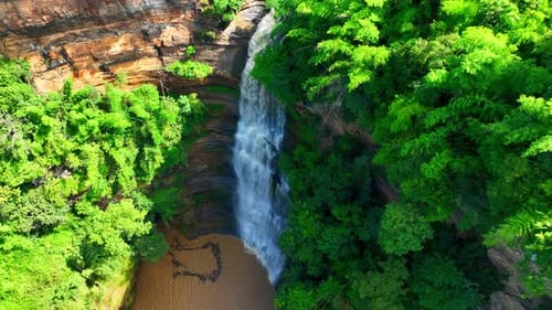 Mesmerizing waterfall, lush greenery, cascading rock layers.