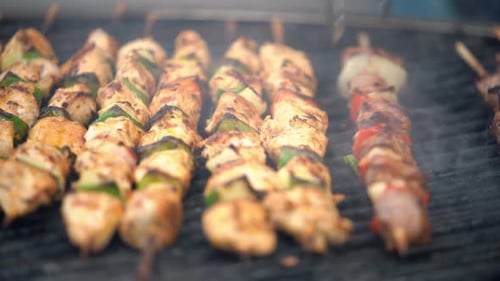 Grilling delicious meat and vegetable skewers at a summer barbecue.