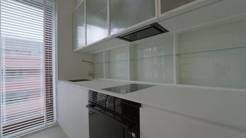Built in oven and cooktop inside brand new renovated empty kitchen interior.