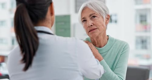 Doctor Examines Senior Woman's Shoulder in Office