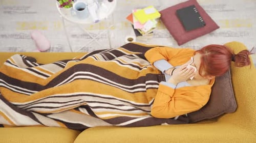 Sick,flu woman on sofa at home.