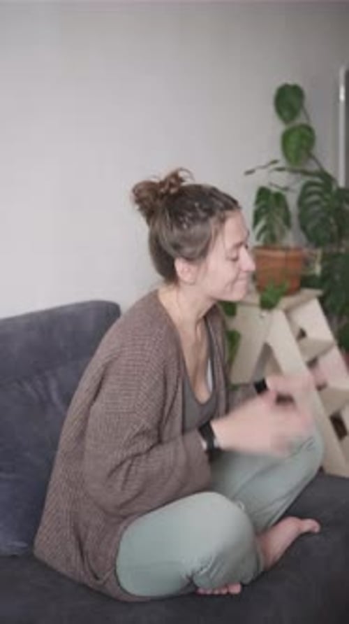Woman Clapping and Dancing While Sitting on Couch