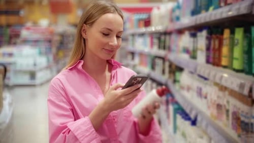 Customer Scanning Product with Smartphone in Supermarket