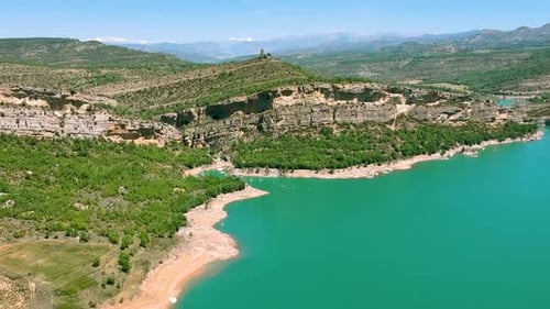Felsenkopf des spanischen Berges, über dessen Fuß das Wasser fließt, grüne Vegetationsdecke, Blau w