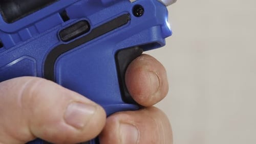 Closeup Finger of Person Pulling Trigger of Screwdriver Side View