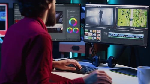 Man Editing Video at Dual Monitor Workstation