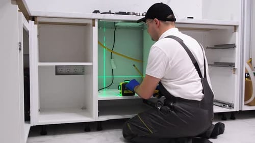 A Worker Installs Furniture in the Kitchen