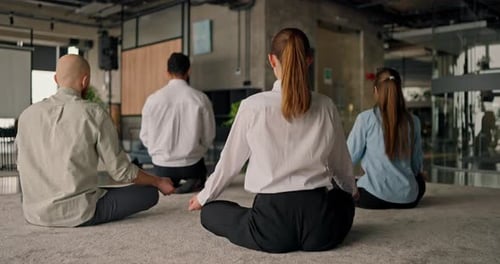 An Overview of Office Workers in Business Attire Meditating on a Grey Carpet Balancing Mental Health