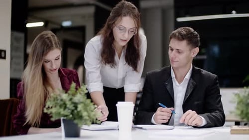 Professionals Discuss Documents in a Modern Office