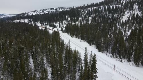 4K Drone Shot of Train in Snowy Mountains