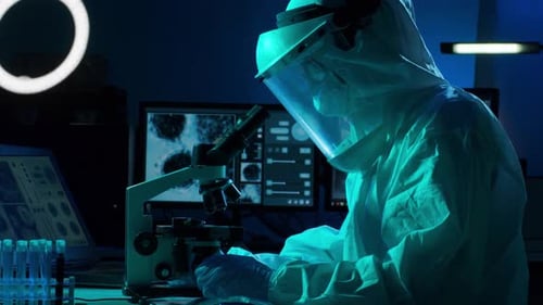 Scientist Works with Microscope in Dark Lab