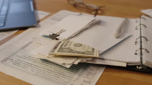 Income Tax Declaration Form and US Dollars on Table at Home