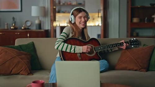 Woman Plays Guitar, Sings at Home