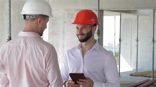 Construction Engineer Engages in Discussion While Holding a Digital Tablet