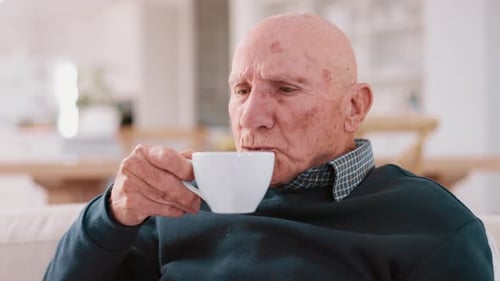 Senior man, coffee and thinking in lounge, sofa and peaceful to relax, drinking and alone