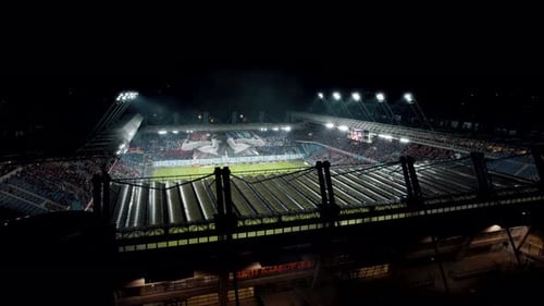 Aerial view of professional football stadium during match, nightlight, fans; 4k
