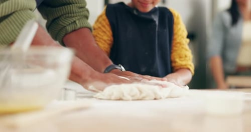 Child and Adult Kneading Dough in Kitchen