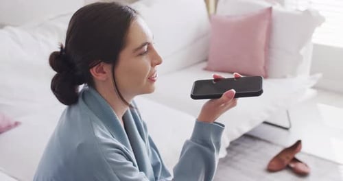 Woman Using Voice Message on Mobile Phone Indoors