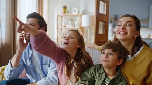 Happy family watching TV together at home