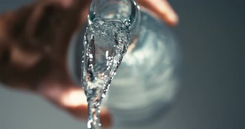 fresh, clear, healthy water flowing out of elegant glass bottle, stay hydrated in life, care for you