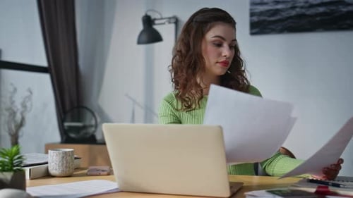 Focused Woman Working with Laptop and Documents