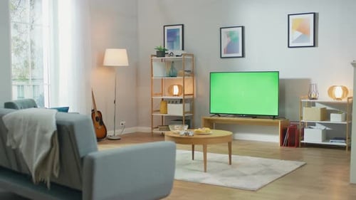 Cozy Living Room with Stylish Furniture and Design, Green Chroma Key TV in the Middle of the Room.