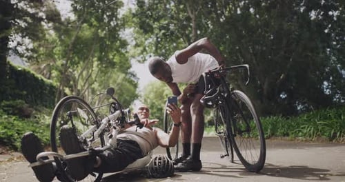 Two handsome men using a cellphone before cycling through the woods together