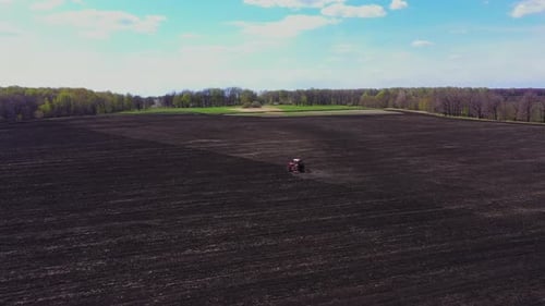 Tractor Plows the Field in Spring
